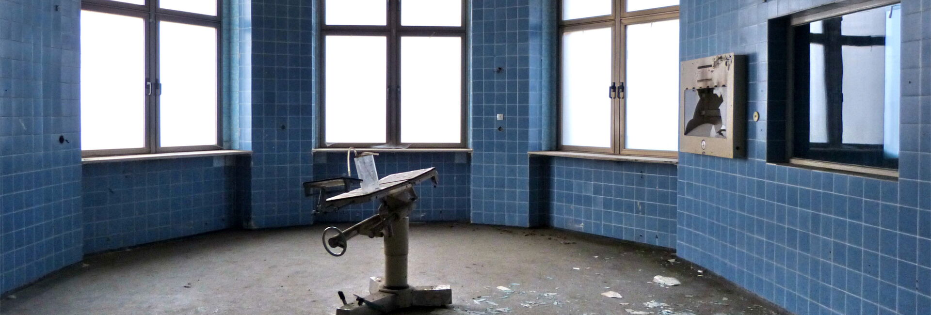 Runder, verlassener Raum mit blauen Fliesen.